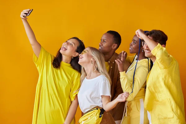 Şık uluslararası gençlik grubu sarı arka planda izole edilmiş selfie çekiyor. — Stok fotoğraf