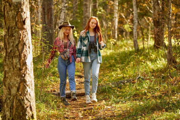 Две дружелюбные женщины, гуляющие вместе, идут вперед в лесу — стоковое фото