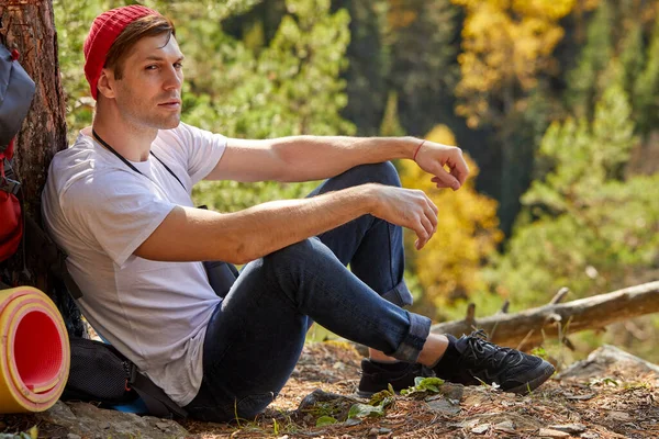 Despreocupado viajante masculino relaxar na borda de um topo de montanha — Fotografia de Stock