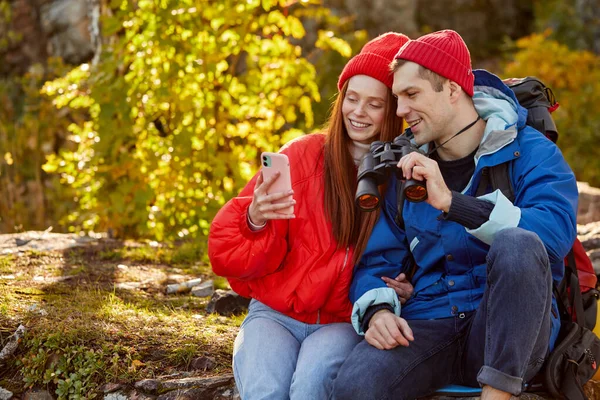 Kaukázusi pár pihenés a hegyekben, okostelefon használata — Stock Fotó