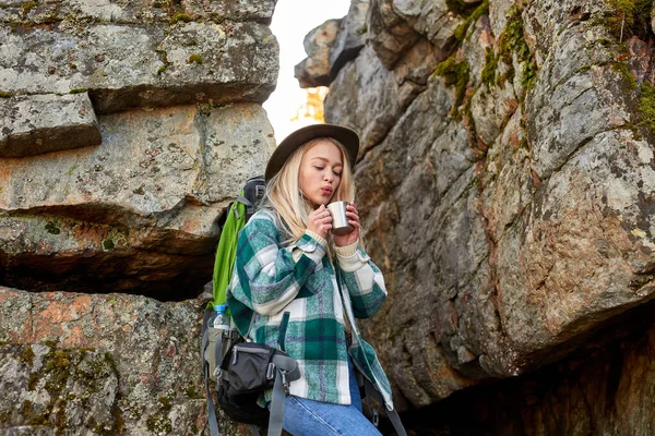 Encantador loira fêmea está bebendo chá quente durante caminhadas — Fotografia de Stock