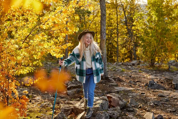 Sportive hiking woman is climbing mountains using hiking cane — Stock Photo, Image