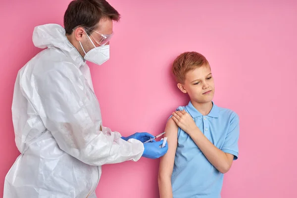 Man läkare som ger vaccin skott till skrämda barn pojke — Stockfoto