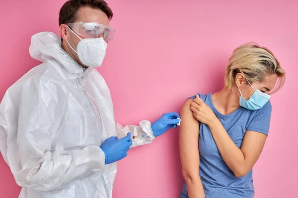 Médico dando vacina tiro para mulher caucasiana assustada — Fotografia de Stock