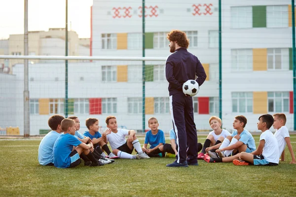 Treinador de futebol confiante ensinar, instruir meninos crianças — Fotografia de Stock