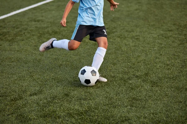 Niño niño pateando pelota de fútbol en el campo de deportes —  Fotos de Stock