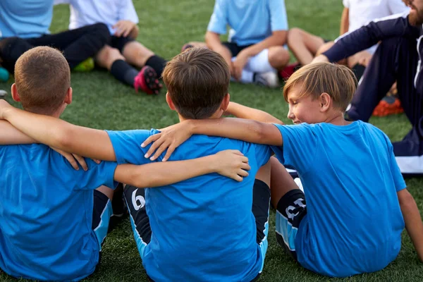 Equipo de fútbol de los niños se abrazan en el campo de fútbol antes del partido — Foto de Stock