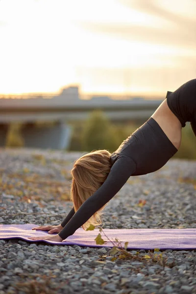 Гибкая женщина делает упражнения yoga на циновке, с наклоненной головой — стоковое фото