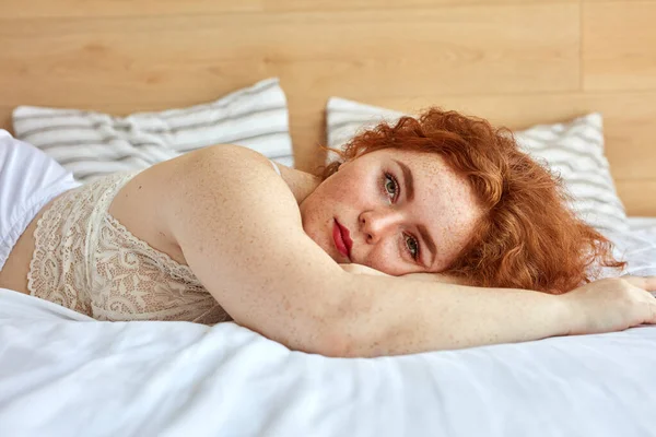 Pelirroja gordita mujer en lencería se encuentra en la cama, descansar —  Fotos de Stock