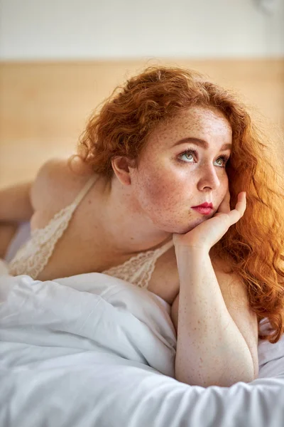 Porträt einer verträumt entspannten molligen Kaukasierin auf dem Bett — Stockfoto