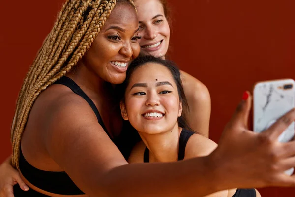 Vriendelijke diverse vrouwen nemen selfie in studio geïsoleerd — Stockfoto