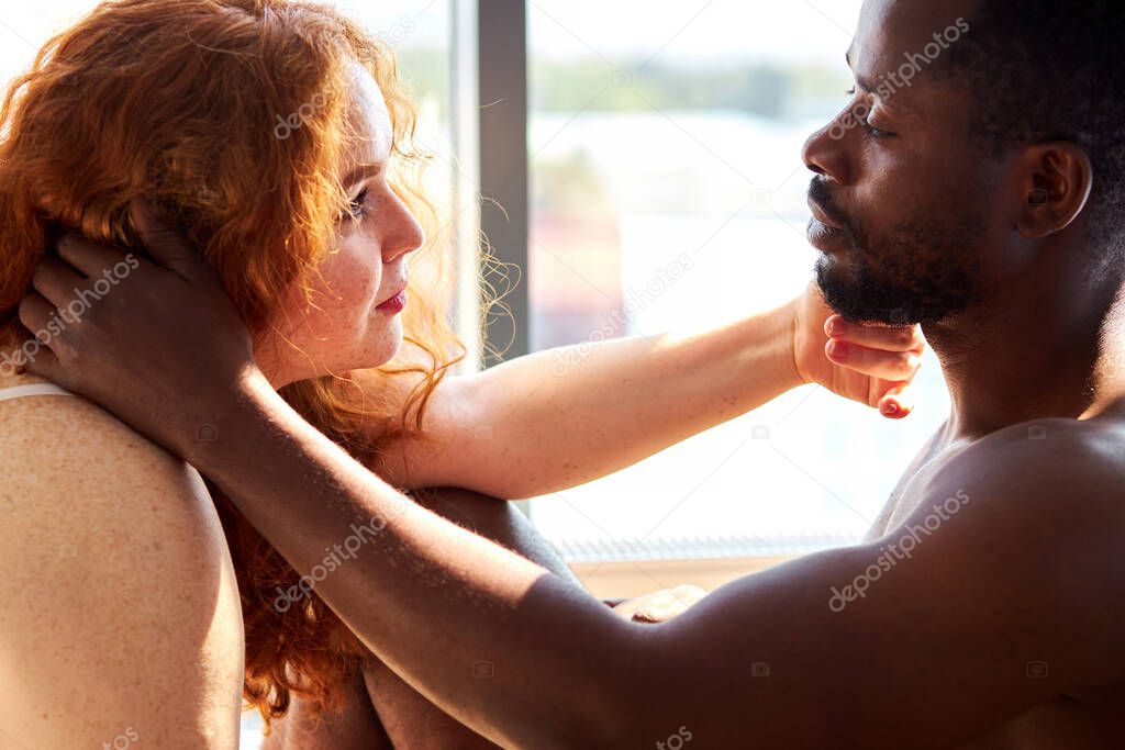 passion between tender interracial diverse man and woman at home
