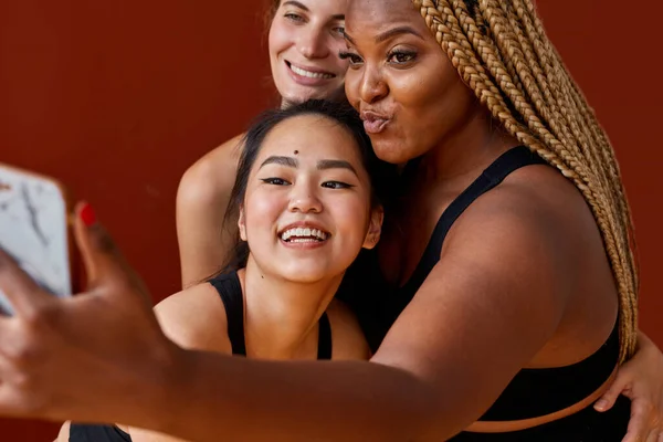 Farklı ırk ve beden ölçülerinde üç farklı etnik kadın model izole edilmiş kamerada selfie çekiyor. — Stok fotoğraf