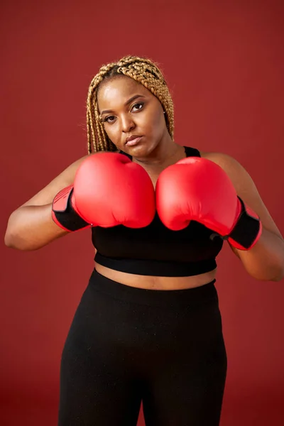 自信満々の太ったアフロ系アメリカ人女性がボクシンググローブを身につけて戦う姿を — ストック写真