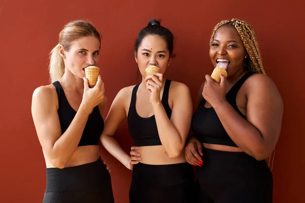 多民族の正の女性のグループは、おいしいアイスクリームを食べる隔離された — ストック写真