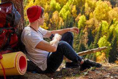 Dağlarda yürüyüş yaparken mola alan gezgin adama yan bakış