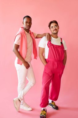 Pembe elbiseli iki yakışıklı adam yalnız poz veriyor.