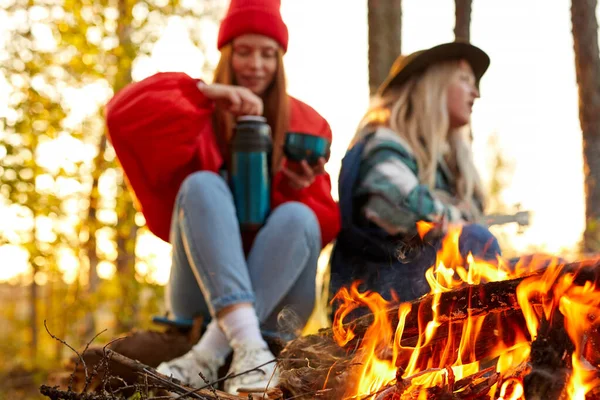 Due donne accanto al falò nella natura, concentrarsi sul fuoco — Foto Stock