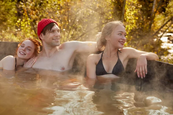 Gençler açık havada banyo yapıyor.