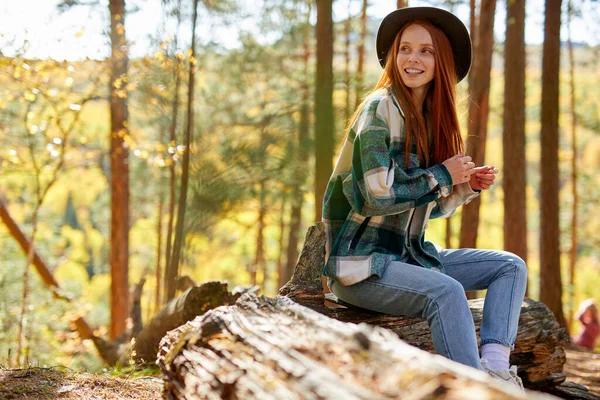 Zijaanzicht op positieve roodharige vrouw kijken weg in het bos — Stockfoto