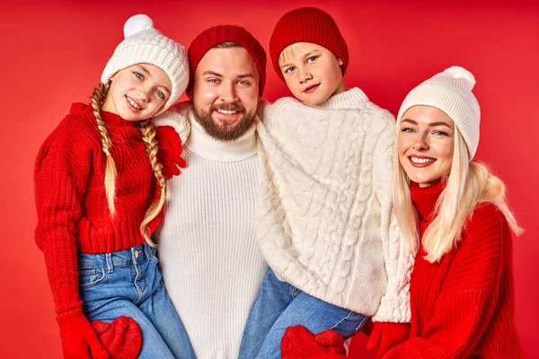 Retrato de familia sonriente positiva con niños aislados en la pared roja —  Fotos de Stock