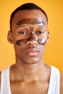 T Bölgesi 'nde maske takan kendinden emin Afro-Amerikan bir adamın portresi.