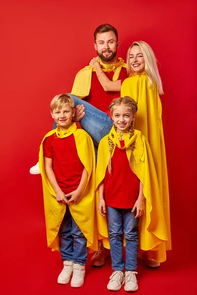 Good-looking parents playing superheroes with children — Stock Photo, Image