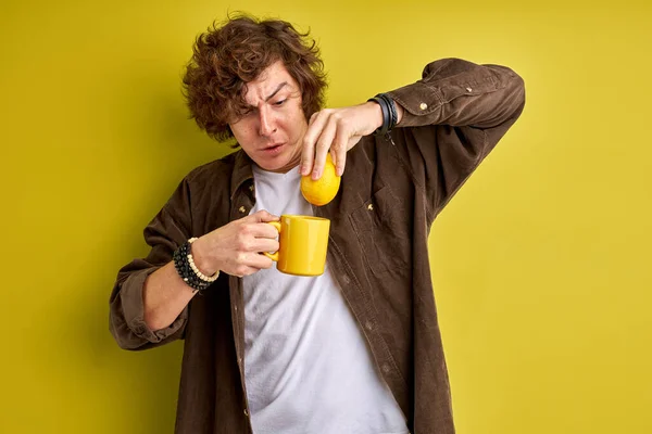 Kaukasisk oro sjuk ung vuxen man har influensa, förbereder te med citron — Stockfoto