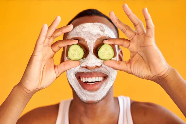 Hombre postive aplicar mascarilla facial con pepino, expresar emociones positivas —  Fotos de Stock