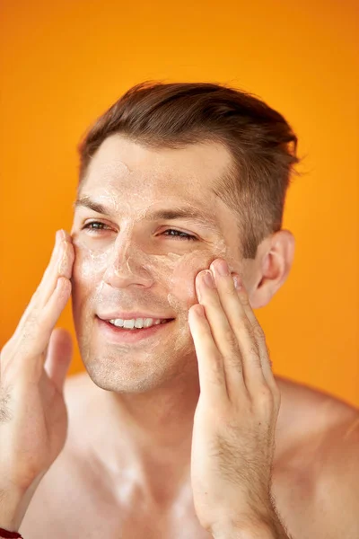 Europejski facet nawilża twarz dla otrzymywać zdrową skórę — Zdjęcie stockowe