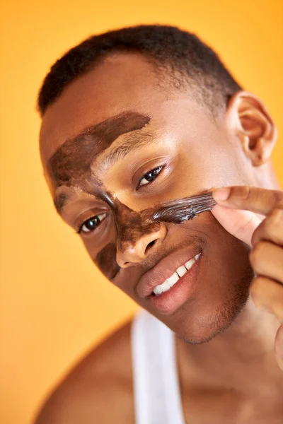 Homem afro-americano bem parecido está tirando máscara facial preta — Fotografia de Stock