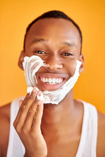Guapo afroamericano hombre está aplicando espuma de afeitar antes de afeitarse cerda — Foto de Stock