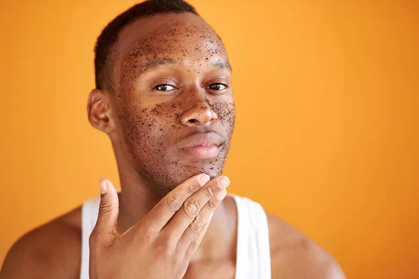 Homme africain applique gommage sur le visage isolé sur fond orange — Photo