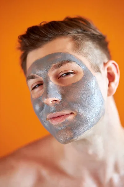 Portrait of cute caucasian man with clay mask on face — Stock Photo, Image