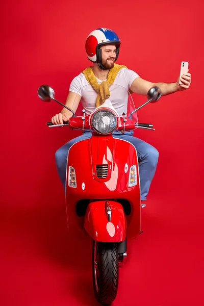 handsome biker man is taking photo while driving