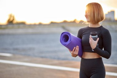 Hoş bir atletik kadın dinleniyor, spor yaparken temiz hava alıyor.