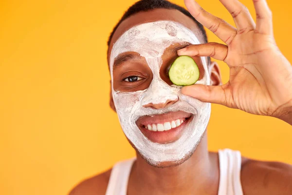 Portrett av en glad gal mann som nyter ansiktsmaske med et stykke agurk – stockfoto