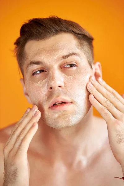 Avrupalı adam sağlıklı cilt için yüzü nemlendiriyor — Stok fotoğraf
