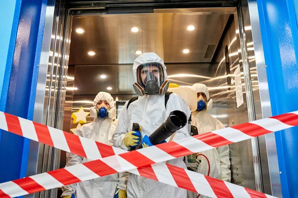 Team av professionella desinfektionsmedel som kommer in i byggnaden — Stockfoto
