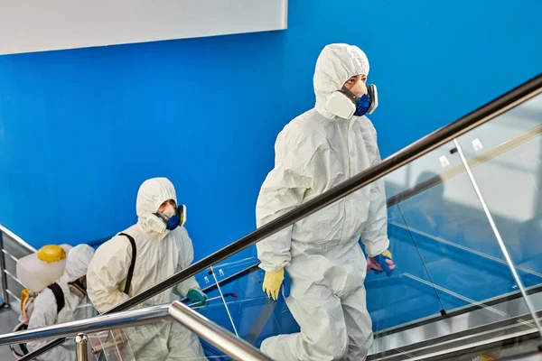 Οι άνθρωποι με στολές προστασίας από ιούς θα καθαρίσουν το κτίριο. — Φωτογραφία Αρχείου