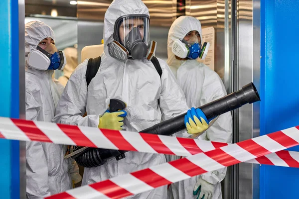 Personas en materiales peligrosos haciendo limpieza en el edificio de apartamentos — Foto de Stock