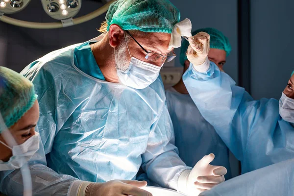 Sala cirúrgica equipe caucasiana de cirurgiões profissionais e enfermeiros que trabalham juntos — Fotografia de Stock