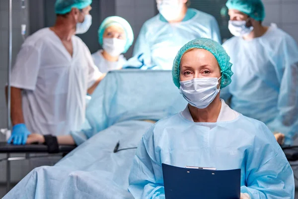 Retrato de assistente de médicos que está fazendo operação ao paciente — Fotografia de Stock