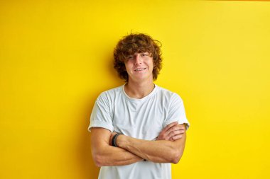 Kıvırcık saçlı adam kameraya bak.