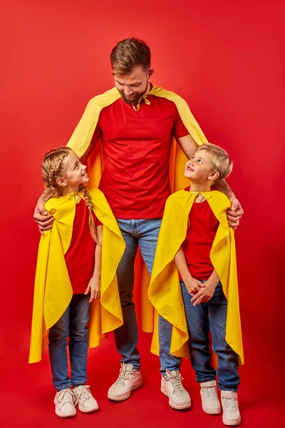 Jeune beau père en costume de super-héros est responsable des enfants — Photo