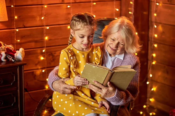 Bela menina branca e avó lendo um livro — Fotografia de Stock