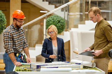 Kadın tasarımcı, mühendislere yol tarifi verir.