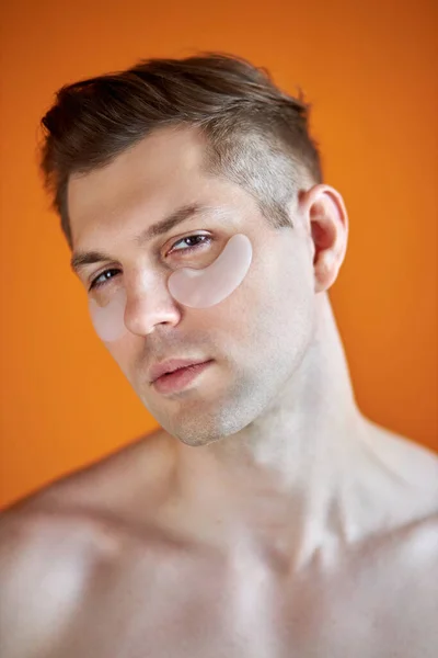 Πορτρέτο του καυκάσιου αρσενικού χρησιμοποιώντας διαφανή μπαλώματα για ρυτίδες κάτω από τα μάτια — Φωτογραφία Αρχείου