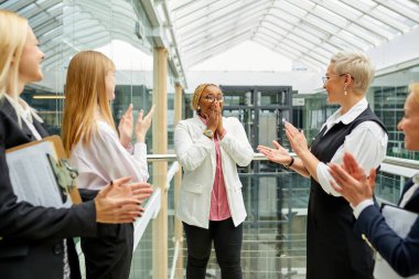 İş yerinde başarılı olan Afrikalı iş arkadaşını tebrik eden dost canlısı meslektaşlar