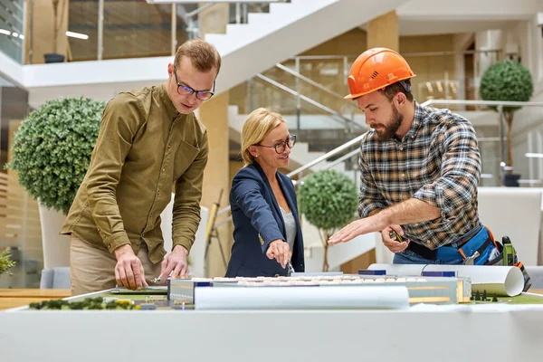 Volwassen vrouw specialist architect check het project lay-out van het gebouw — Stockfoto